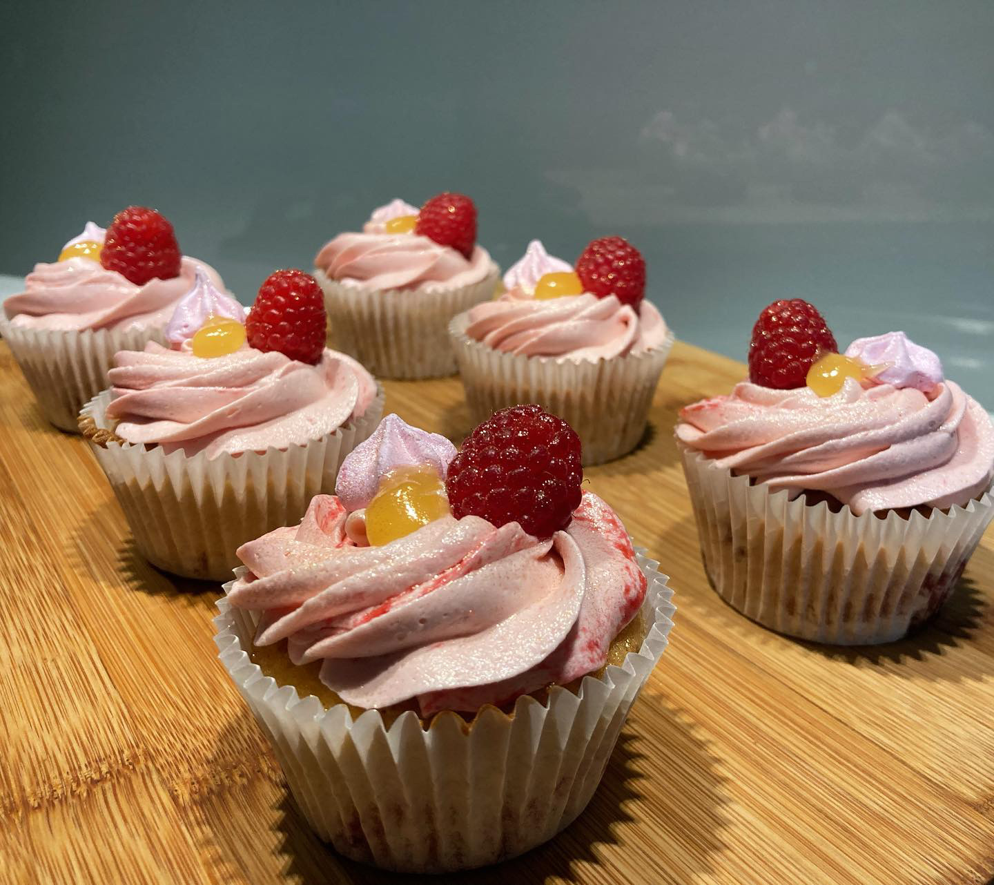 Raspberry cupcakes with pink buttercream, fresh raspberries and lemon curd